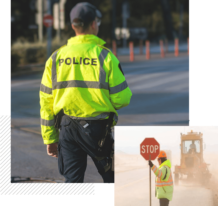 A police officer is standing on the side of the road.